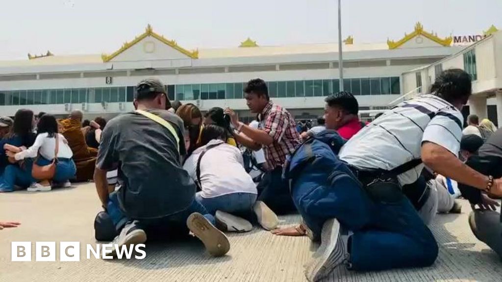 5People crouch on the tarmac in Mandalay airport